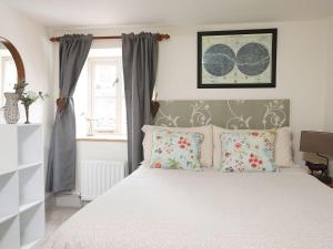 a bedroom with a white bed with pillows at Kielder Cottage - E3533 in Kielder