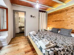 - une chambre avec un grand lit et un mur en bois dans l'établissement CAN FRUITÓS Alojamiento rural en Besalú, à Besalú