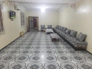 uma sala de estar com um sofá e uma mesa em Bol d'air à la mer centre Ain el Turck em Aïn el Turk