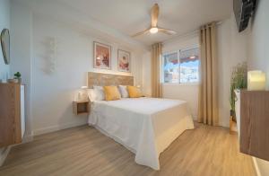 1 dormitorio con cama blanca y ventana en Tucan Playa, en La Herradura