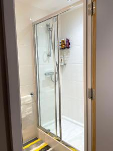 a shower with a glass door in a bathroom at HNFC Stays - Modern central studio with Gym, Parking & Home Cinema in Newcastle upon Tyne