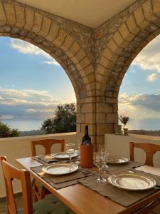 una mesa con copas y una botella de vino en Horizon Villa Mani - Seaview Family Friendly House, en Stoupa