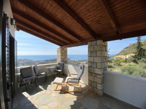 patio con sillas, mesa y vistas en Horizon Villa Mani - Seaview Family Friendly House, en Stoupa