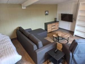 a living room with a couch and a tv at camping family room in Ter Aar