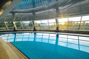 una gran piscina con suelo de baldosa azul y ventanas en Hotel Belweder en Ustroń