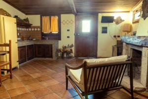 uma cozinha com uma cadeira e uma lareira em Green Village em San Giorgio a Liri