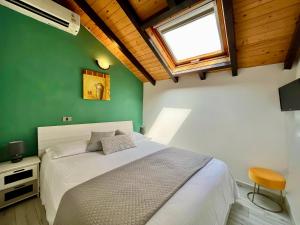 una camera con un letto bianco e una parete verde di Hotel Alla Fontanella ad Alassio