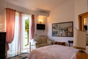 um quarto com uma cama, um sofá e uma janela em Green Village em San Giorgio a Liri