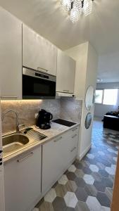 cocina blanca con fregadero y fogones horno superior en Pietranera studio proche de la mer à 2km de Bastia en Palagaccio