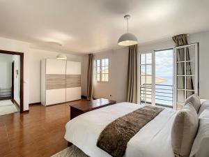 una camera da letto con un letto grande e una grande finestra di Villa Formosa View by Atlantic Holiday a Funchal