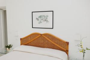 une chambre avec une tête de lit en bois et une photo sur le mur dans l'établissement Villa l'Approdo, à Anacapri