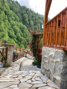 a stone walkway with a wooden fence and flowers at Ayder Bulut Dağevi Bungalow in Ayder Yaylasi