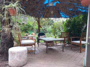 un patio con sillas, una mesa y una parrilla en גינה ירושלמית en Jerusalem