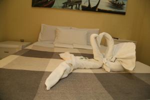 una camera da letto con un letto con asciugamani a forma di cigno di Hotel Veleiro de Porto a Porto De Galinhas