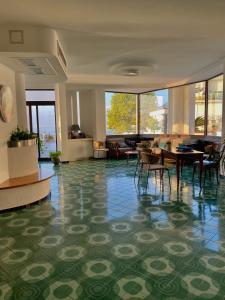un vestíbulo con mesas y sillas en un edificio en Hotel La Lucertola, en Vietri