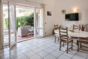 een woonkamer met een tafel en stoelen en een patio bij N169 - Numana, nuova villa quadrilocale con giardino in Numana
