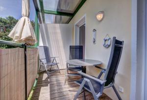 Un patio con sillas y una mesa en el balcón. en Zinnowitz, Ferienwohnung Margarete, en Zinnowitz