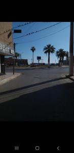 an empty street with palm trees in the distance at Bol d'air à la mer centre Ain el Turck in 'Aïn el Turk