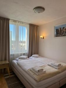 a bedroom with two beds and a large window at Apartament Bazyliańska - 100m do Metra "Bródno", 20 minut do centrum Warszawy in Warsaw