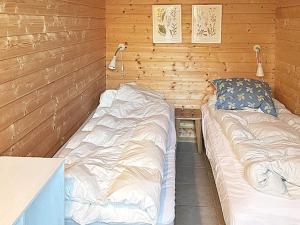 a room with two beds in a wooden wall at Holiday home Nykøbing Sj II in Tjørneholm