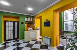 um homem parado num balcão numa sala com paredes amarelas e verdes em Moss Art Boutique Hotel em Baku