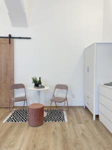 a white kitchen with two chairs and a table at DMR Apartments in Košice