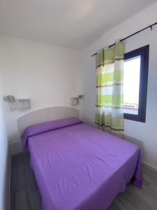 a bedroom with a purple bed and a window at Nora's Flats in Triscina