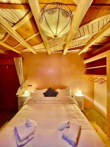 una camera da letto con un grande letto con due asciugamani di Chateau Imilchil a Imilchil