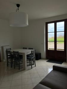 una sala da pranzo con tavolo, sedie e finestra di Acero a Cortona
