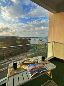 una mesa en un balcón con vistas al agua en Mari Mari Homestay - IMAGO THE LOFT, en Kota Kinabalu