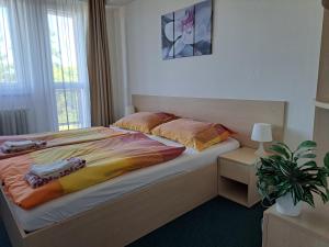 a bedroom with a bed and a potted plant at Hotel Centrum Brno in Brno