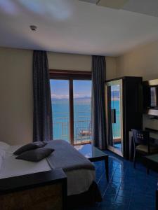 a bedroom with a bed and a view of the ocean at Hotel La Lucertola in Vietri sul Mare