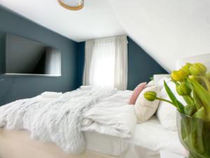 - une chambre avec un lit blanc et un mur bleu dans l'établissement M-Style 03 Apartment 24h Self-Check-In, Free Parking, Netflix, à Nuremberg