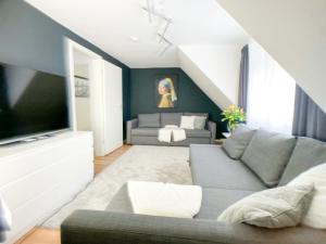 een woonkamer met een bank en een tv bij M-Style 03 Apartment 24h Self-Check-In, Free Parking, Netflix in Neurenberg