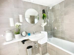 a bathroom with a sink and a tub and a mirror at M-Style 03 Apartment 24h Self-Check-In, Free Parking, Netflix in Nuremberg