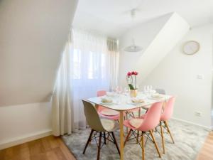 een eetkamer met een witte tafel en roze stoelen bij M-Style 03 Apartment 24h Self-Check-In, Free Parking, Netflix in Neurenberg