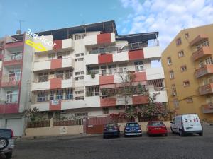 a building with cars parked in front of it at Cubico Tota in Praia