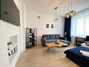 - un salon avec un canapé et une table dans l'établissement Apartament Midnight Blue, à Mielec