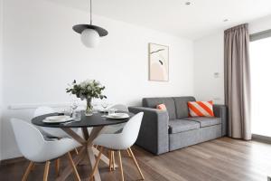 numa I Colmena Apartments في برشلونة: غرفة معيشة مع طاولة وأريكة