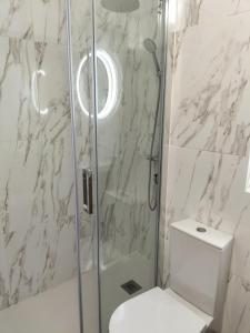 a bathroom with a toilet and a glass shower at T2 Vista Atlantica 3 minutos da praia de Quarteira in Quarteira +24 photos