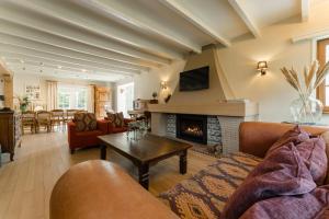 a living room with a couch and a fireplace at De zandberg Vakantiewoning in Neerpelt