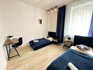 - un salon avec deux lits et un bureau dans l'établissement Apartament Midnight Blue, à Mielec