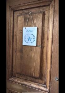 un cartello su una porta di legno con un cartello sopra di LePetit a Porto Santo Stefano