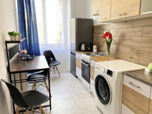 a kitchen with a washing machine and a table with chairs at Apartament Midnight Blue in Mielec