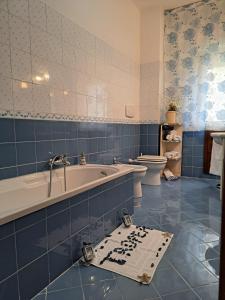 ein blau gefliestes Bad mit einer Badewanne und einem WC in der Unterkunft TERRA D'AMURI Tropea in Tropea