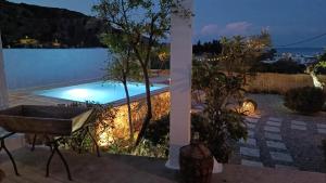 una bañera sentada junto a una piscina por la noche en Ktima Natura, en Archangelos