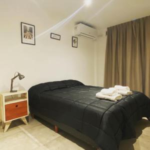 a bedroom with a bed with two towels on it at FINCA NOVA Apartment 1 in Balcarce