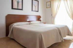 a bedroom with a large bed with a wooden headboard at Los Gallos in Casabermeja