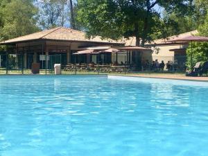 a pool of blue water in front of a building at Maison bois au bord du lac in Lacanau
