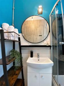 La salle de bains est pourvue d'un lavabo et d'un miroir. dans l'établissement Apartament Midnight Blue, à Mielec
